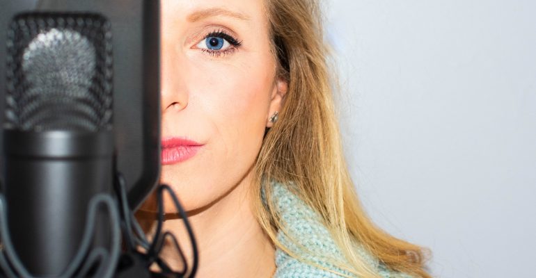 5 Questions to Ask a Voice Actor Before Recording - Female voice artist with microphone