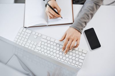 How to Quickly Transcribe a YouTube Video to Text — Woman Transcribing in a Notebook
